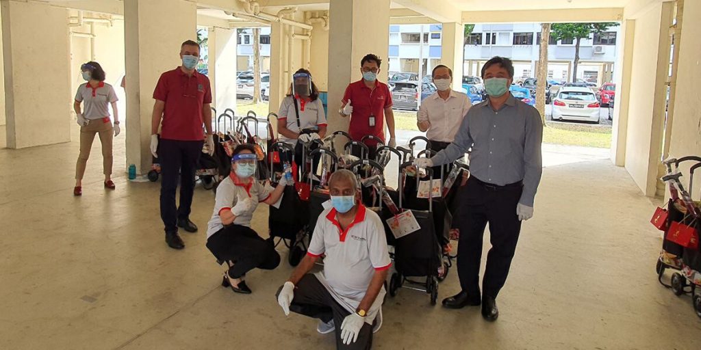 Group of volunteers standing with prepared bags for distribution