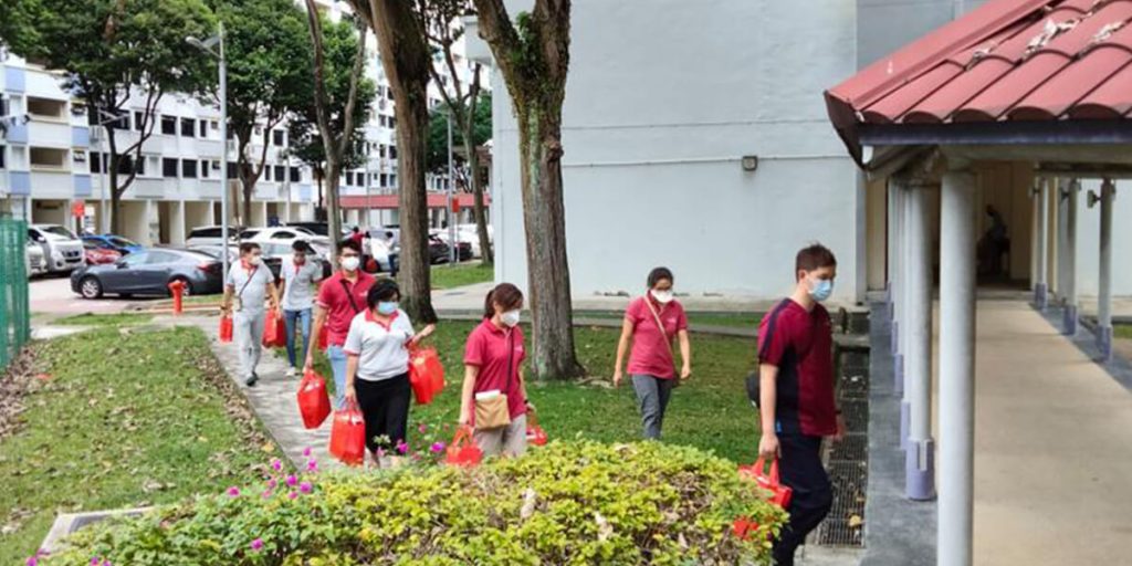 Volunteers walking through a neighbourhood to distribute care packs
