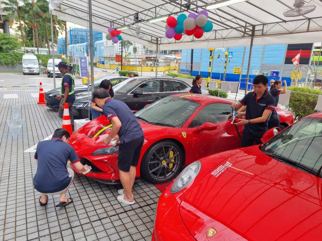 Charity car wash with volunteers cleaning cars outdoors