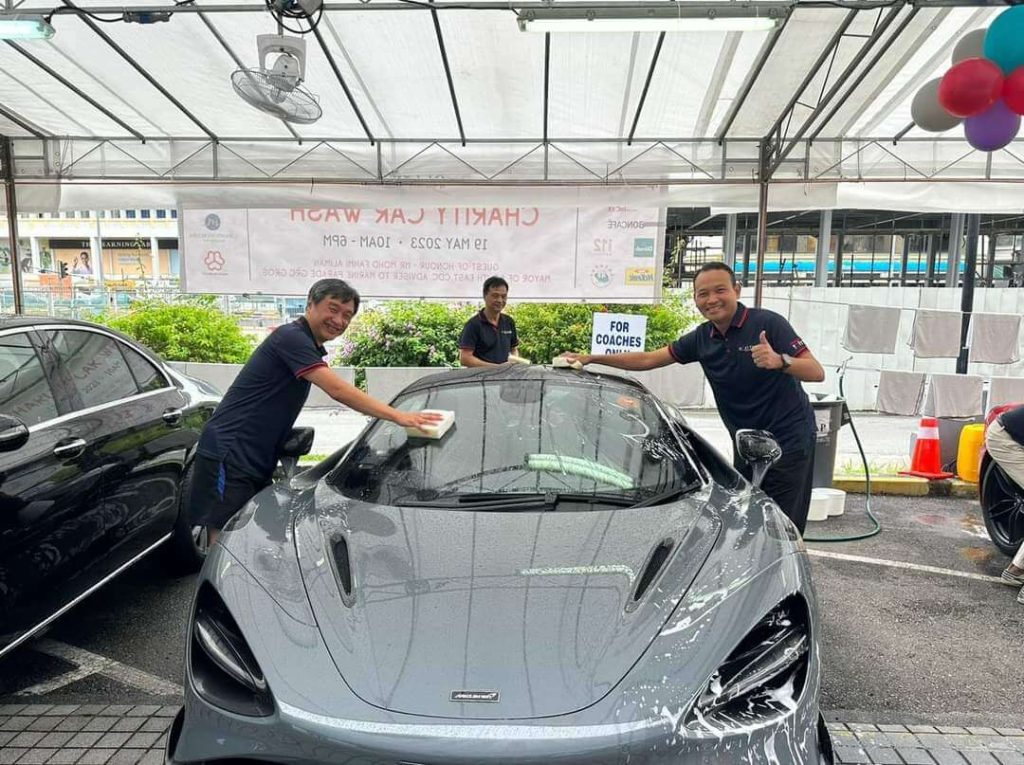 Team members washing cars at a charity car wash event