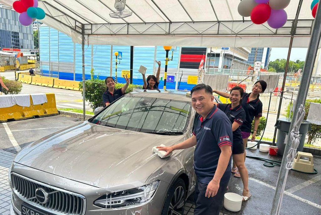Outdoor car washing activity with volunteers